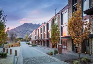 a street with buildings and a mountain in the background at DoubleTree by Hilton Queenstown in Queenstown