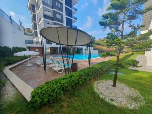 a garden with a pool and a building at A dreamy luxury one-bedroom apartment with special views of the forest, sea and sunset in Alanya