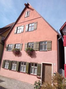 a pink building with windows and flowers on it at Casa Wüstner in Dinkelsbühl