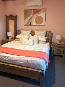 ein großes Bett in einem Schlafzimmer mit zwei Nachttischen in der Unterkunft Rustic on 13th in Gawler