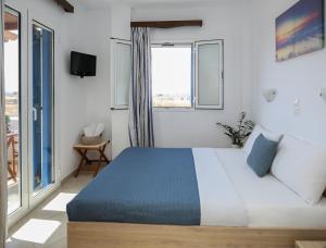 a bedroom with a bed and a large window at Joanna Apartments in Mikri Vigla