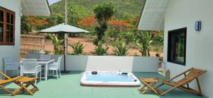 a hot tub on a patio with chairs and a table at พรพนาฮิล4 in Lamphun