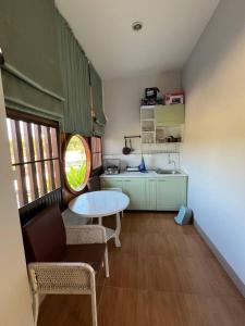a small room with a table and a kitchen at พรพนาฮิล4 in Lamphun