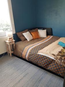 a bed with pillows on it in a bedroom at Chambre double chez l'habitant proche du circuit in Le Mans