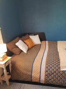 a bedroom with a bed with pillows and a table at Chambre double chez l'habitant proche du circuit in Le Mans