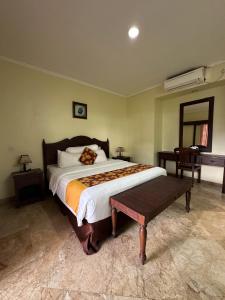 a bedroom with a large bed with a bench in it at Lorin Resort Belitung in Sijuk