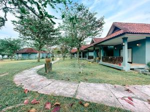 a house with a walkway in front of a yard at Lorin Resort Belitung in Sijuk