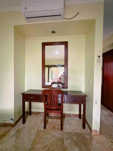a desk in a room with a chair and a mirror at Lorin Resort Belitung in Sijuk