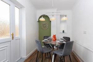 a dining room with a table and chairs and a clock at 4BR Home with Parking Ideal for Contractors in Durham