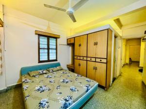 a bedroom with a bed and wooden cabinets and a window at Flora 2bhk Kothrud MIT WPU in Pune