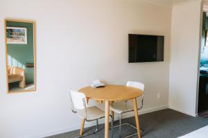 a table and chairs in a room with a tv at The Mayfair in Hastings