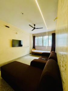 a living room with two beds and a couch at Flora 2bhk Kothrud MIT WPU in Pune +37 photos
