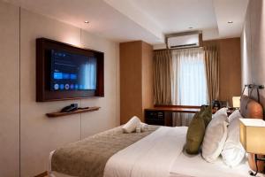a hotel room with a bed with a television on the wall at The Green Hall in George Town