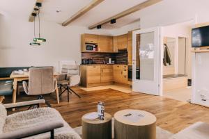 a living room with a table and a kitchen at Almresort Gartnerkofel Nassfeld in Sonnenalpe Nassfeld