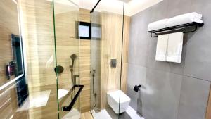 a bathroom with a glass shower with a toilet at Aurhom By Royal Inn in Karachi +19 photos