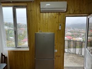 a refrigerator in a room with a balcony with windows at Apartment BESO in Kutaisi