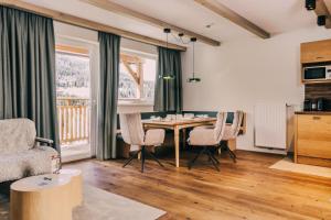 a living room with a table and chairs at Almresort Gartnerkofel Nassfeld in Sonnenalpe Nassfeld
