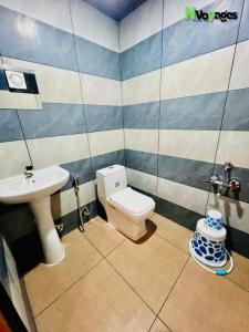 a bathroom with a toilet and a sink at Nvoyages Wayanad in Wayanad +67 photos