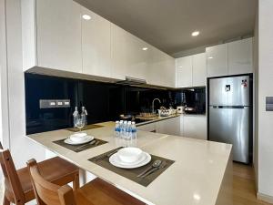 a kitchen with a table with two plates and a refrigerator at Star Residence KLCC By BluekeyKL in Kuala Lumpur