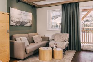 a living room with a couch and two chairs at Almresort Gartnerkofel Nassfeld in Sonnenalpe Nassfeld +70 photos