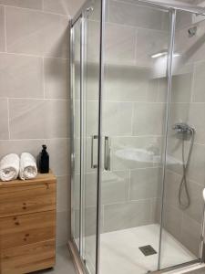 a shower with a glass door in a bathroom at Casco antiguo en Ribadesella in Ribadesella +14 photos
