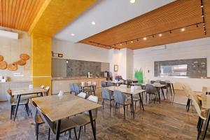 a restaurant with tables and chairs and a kitchen at House16 in Green Island
