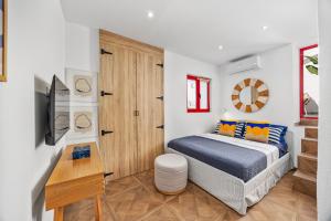 a bedroom with a bed and a desk and a television at Coral Alvor Old Town Marina Townhouses Collection in Alvor
