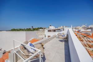 a balcony with chairs on the roof of a building at Coral Alvor Old Town Marina Townhouses Collection in Alvor