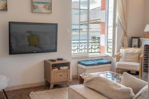 a living room with a flat screen tv on the wall at Villa authentique Vue mer 360 Les pieds dans l’eau in Larmor-Plage +56 photos