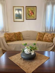 a living room with a couch and a vase on a table at Athevillas Antonis in Mína