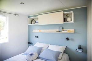 a bedroom with blue walls and a bed with pillows at ZEcamping chiens acceptés animations parc aquatique in Saint-Hilaire-de-Riez