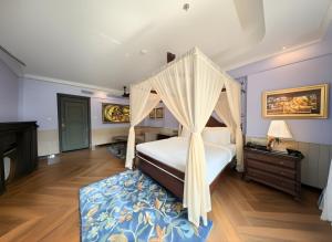 a bedroom with a canopy bed and a wooden floor at Mayfair Bay Resort Paradeep in Parādīp Garh