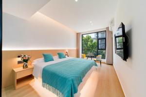 a bedroom with a bed and a large window at Yangshuo YeQi Hotel in Yangshuo