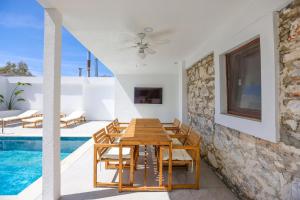 a dining room with a table and chairs next to a swimming pool at Traditional Seaside Stone Villa with Private Pool in Bodrum City +23 photos