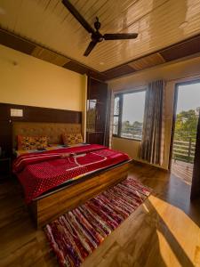 a bedroom with a large bed and a rug at BirAlive Cafe & Homes in Bīr