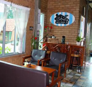 a restaurant with chairs and a table and a sign at MatanaCafe&Resort in Ban Bo Nam Khao
