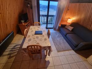 a living room with a table and a couch at Là-Haut in Les Angles