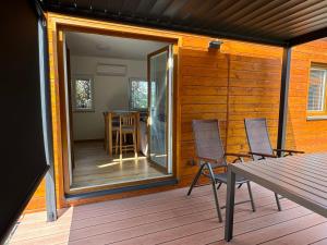 a screened in porch with a table and chairs on a deck at Domky Slapy pod golfem in Slapy