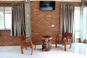 a room with two chairs and a table and a tree stump at MatanaCafe&Resort in Ban Bo Nam Khao