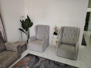 two chairs and a table in a living room at Miqayla Homestay in Wakaf Baharu
