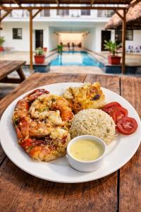 a plate of food with shrimp and rice on a table at TheLight Villa in Trou d'Eau Douce