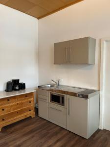 a kitchen with white cabinets and a sink and a counter at Kloster Altenhohenau FHN in Griesstätt
