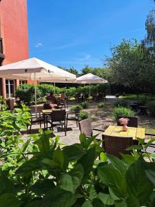 a patio with tables and chairs and umbrellas at Hotel Altamira in Piotrków Trybunalski