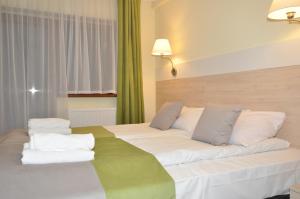 Łóżko lub łóżka w pokoju w obiekcie Pass Hotel