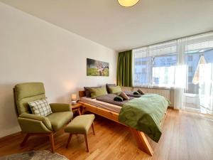 a bedroom with a bed and a chair at Hirschzauber A9 Montana Haus in Oberstdorf +32 photos