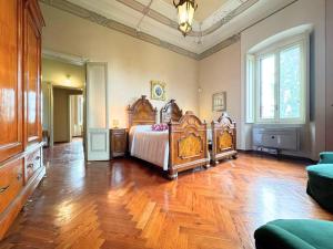 a bedroom with a bed and a wooden floor at Villa Cervi in Ronco Todeschino