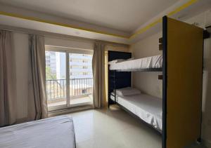 a bedroom with two bunk beds and a balcony at Tapovan Namaste in Rishīkesh