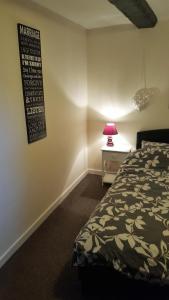 a bedroom with a bed and a sign on the wall at Hathway House Accommodation in Redhill