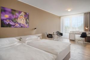 a bedroom with a bed and a table and chairs at PARKHOTEL Hameln in Hameln