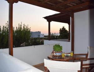 a patio with a table and chairs on a white wall at Joanna Apartments in Mikri Vigla